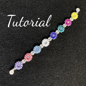 May include: A beaded bracelet with a floral design. The bracelet is made with small, colorful beads and silver beads. The bracelet has a silver clasp.
