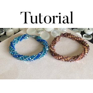 May include: Two beaded bracelets, one blue and one brown, on a white surface. The bracelets are made with small, faceted beads and have a spiral design.