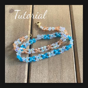 May include: A multi-strand beaded necklace with a gold clasp. The necklace features blue, clear, and peach-colored beads in a flower pattern.