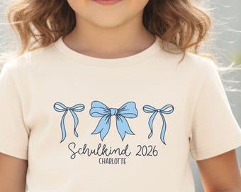 Schleifen Schulkind T-Shirt 2026, personalisiert mit Name, Motiv & Druckfarbe I Geschenk zur Einschulung