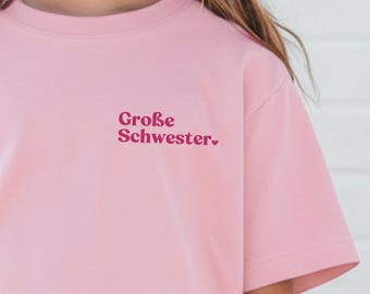 Große Schwester T-Shirt rosa zur Schwangerschaftsverkündung I personalisierbar mit Wunschtext, Jahreszahl & Name I Druckposition wählbar