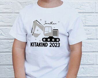 weißes T-Shirt oder Langarmshirt mit Bagger I personalisiert mit Name I Kitakind 2024 I Kindergartenkind / Krippenkind / Krabbelstubenkind