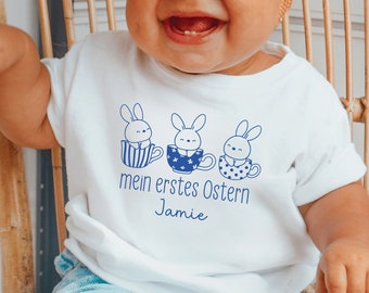 weißer Baby Body "mein erstes Ostern 2024" oder Wunschtext I Osterhase Hase Häschen in Tassen I personalisiert mit Namen