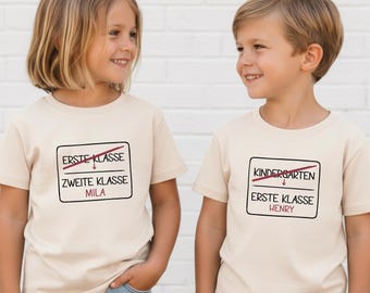 Einschulung & Klassenwechsel Shirt mit Ortsschild Motiv – T-Shirt in creme – personalisiert mit Wunschtext wie erste Klasse → zweite Klasse