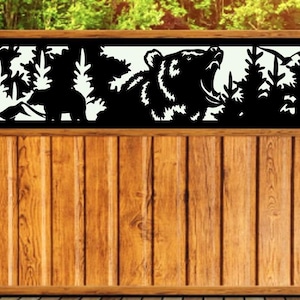 May include: A wooden fence with a black metal insert featuring a silhouette of a bear in a forest setting. The bear is roaring with its mouth open. The insert is framed with a black border.