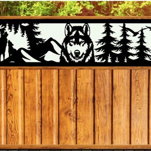 May include: A black metal fence panel with a cutout design of a wolf's head and a forest scene. The panel is mounted on a wooden fence.
