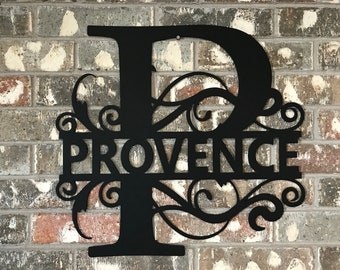 May include: Black metal sign with a decorative scroll design and the letter "P" in the center. The word "PROVENCE" is written across the bottom of the sign.