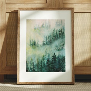 May include: A watercolor painting of a misty forest scene with green trees and a light blue sky. The painting is framed in a wooden frame.