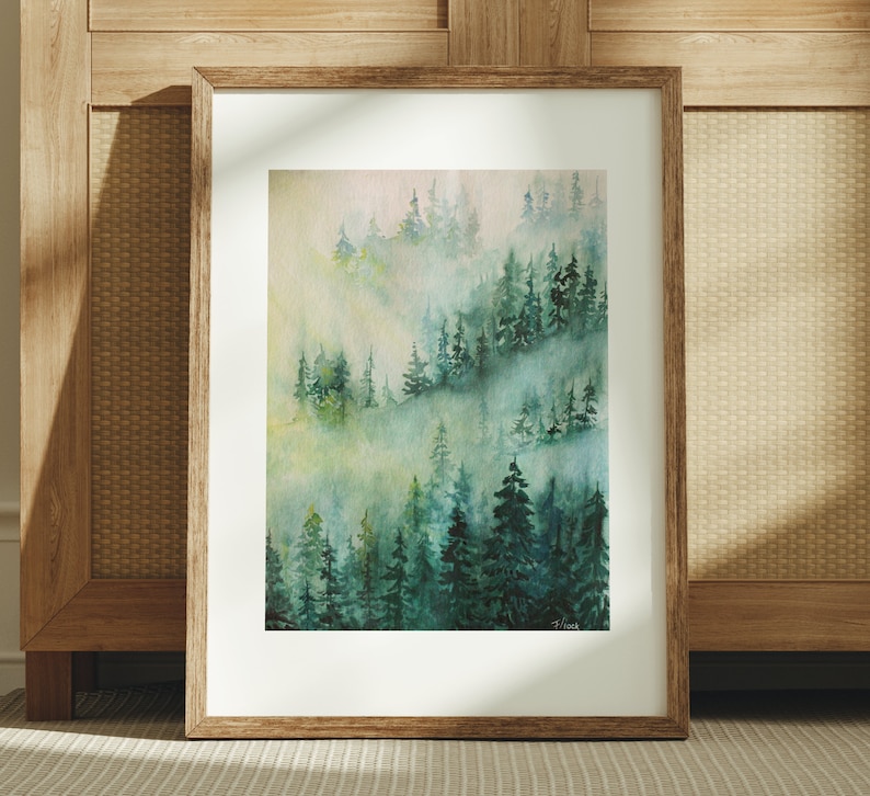 May include: A watercolor painting of a misty forest scene with green trees and a light blue sky. The painting is framed in a wooden frame.