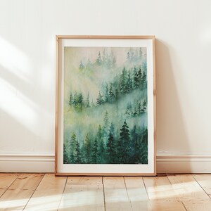 May include: A watercolor painting of a misty forest scene with tall green trees. The painting is framed in a light wood frame.