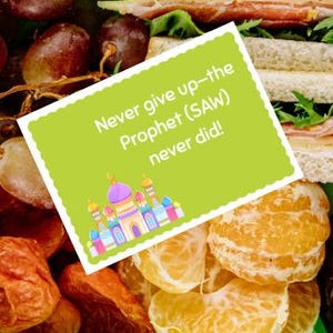 Könnte beinhalten: Ein grüner Behälter gefüllt mit verschiedenen Lebensmitteln, darunter Trauben, Orangen, Datteln und ein Sandwich. Eine grüne Karte mit dem Text "Never give up-the Prophet (SAW) never did!" liegt obenauf, mit einer bunten Moscheedarstellung.