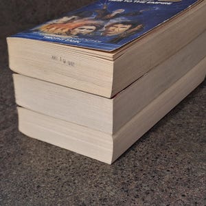 Op de afbeelding: Drie paperback boeken op elkaar gestapeld. Het bovenste boek heeft een blauwe omslag met de titel "Heir to the Empire" en de naam van de auteur, Timothy Zahn. De datum "MAY 19 1992" staat op de rand van de pagina's.
