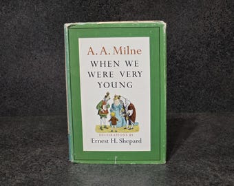 May include: A. A. Milne's "When We Were Very Young" book with a green border. The cover features illustrations of characters in a storybook setting. The book's title and author's name are displayed prominently.