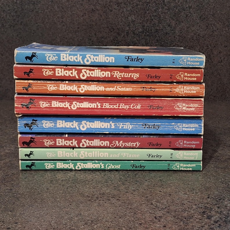 May include: A stack of eight vintage "The Black Stallion" books by Farley. The book spines are in various colors, including blue, red, orange, and green. Each book features the title, author's name, and publisher, Random House.