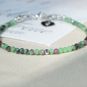 Peut inclure: Un bracelet délicat en pierres précieuses vertes et roses avec un fermoir argenté. Le bracelet est composé de petites perles rondes et est parfait pour un usage quotidien.