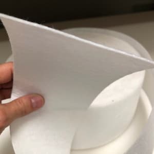May include: White felt fabric, folded in half, showing the soft texture. The felt is thick and appears to be high quality.
