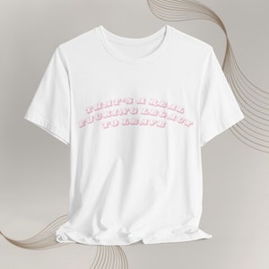May include: White t-shirt with a pink graphic that says "That's a real fucking legacy to leave."
