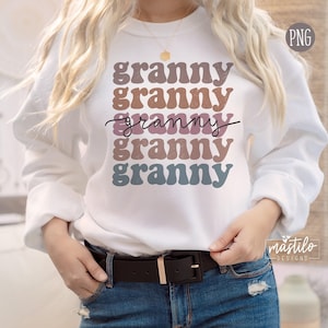 May include: White sweatshirt with the word "granny" repeated five times in a rainbow of colors. The word "granny" is in a retro font style.