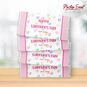 May include: Four pink and white chocolate bar wrappers with a Valentine's Day theme. The wrappers are decorated with colorful candy hearts and the text "Happy Valentine's Day from: Amira".