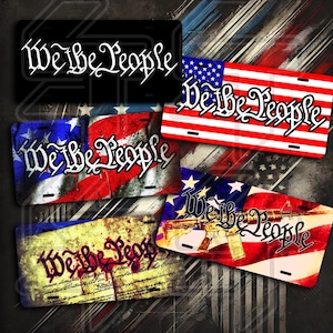 以下が含まれることがあります： 「We the People」という言葉をスタイリッシュなフォントでデザインした、4種類のナンバープレート。プレートには、アメリカ国旗、古びた羊皮紙の背景、ライフルを持ったスタイリッシュなアメリカ国旗など、さまざまな愛国的なデザインが施されています。