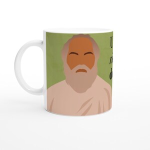 Può includere: Tazza in ceramica bianca con sfondo verde e un'illustrazione di un uomo con la barba e una tunica bianca. Il testo "You are the only you that you've got to be" è stampato sulla tazza.