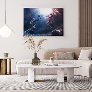 Puede incluir: Una impresi&oacute;n en lienzo enmarcada que representa una escena de batalla con dos figuras en acci&oacute;n, sobre un fondo oscuro y dram&aacute;tico. La obra de arte se exhibe sobre un sof&aacute; beige en un sal&oacute;n moderno. La habitaci&oacute;n incluye una alfombra blanca, una mesa de centro de m&aacute;rmol y una mesa auxiliar dorada.