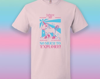 Può includere: Una t-shirt a maniche corte rosa chiaro con una grafica di un unicorno. La stampa include il testo "SEX POSITIVE TARO", "PLEASURE", "CONSENT", "AWARENESS", "NO JUDGEMENT" e "SO MUCH TO EXPLORE!" in inchiostro blu e rosa sul davanti.