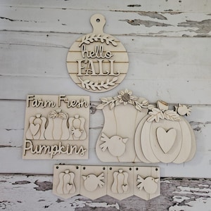 May include: Wooden craft cutouts for fall decor. The cutouts include a round sign that says "hello fall", a sign that says "farm fresh pumpkins", and three pumpkin shapes with birds.
