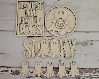 May include: Wooden Halloween decorations featuring the words "I'm just here for the boos" and "Spooky", a ghost holding a jack-o-lantern and several smaller ghosts.