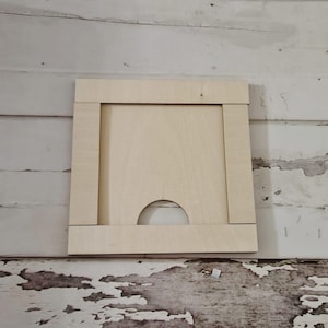 May include: A light wood frame with a cutout in the shape of an arch. The frame is unfinished and ready to be painted or stained.