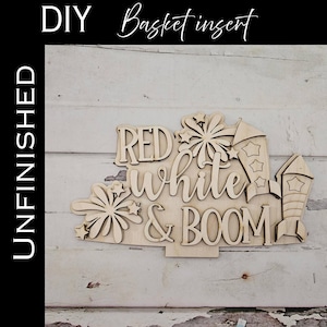 May include: Unfinished wooden basket insert with the words "RED, WHITE & BOOM" and firework and rocket ship designs. The words "DIY" and "UNFINISHED" are also visible.