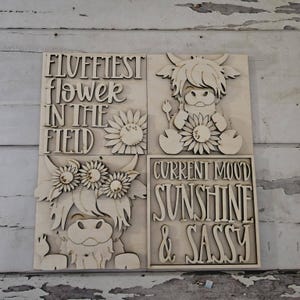 May include: Four wooden panels with laser-cut designs. One panel reads "Fluffiest Flower in the Field" with a sunflower. Another features a Highland cow with a sunflower. The third panel shows a cow with a sunflower crown. The last panel says "Current Mood Sunshine & Sassy."