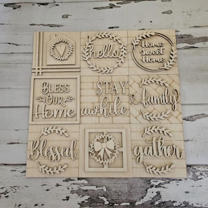 May include: Nine unfinished wooden signs with various home-themed phrases, including "Bless Our Home", "Stay Awhile", "Family", "Gather", "Home Sweet Home", and "Hello".
