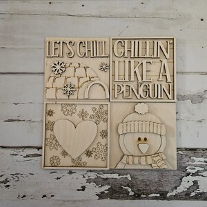 Könnte beinhalten: Holzzeichen mit vier Feldern. Das obere linke Feld sagt "Let's Chill" und hat ein Schneeflocke und ein Iglu-Design. Das obere rechte Feld sagt "Chillin' Like A Penguin". Das untere linke Feld hat eine Herzform und Schneeflocken. Das untere rechte Feld hat einen Pinguin mit einem Schal und einer Mütze.