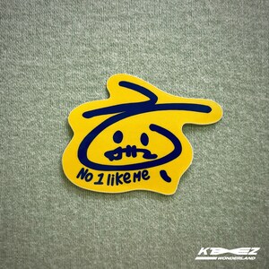 May include: Yellow sticker with a blue outline of a face with a frown and the text "No 1 like me".