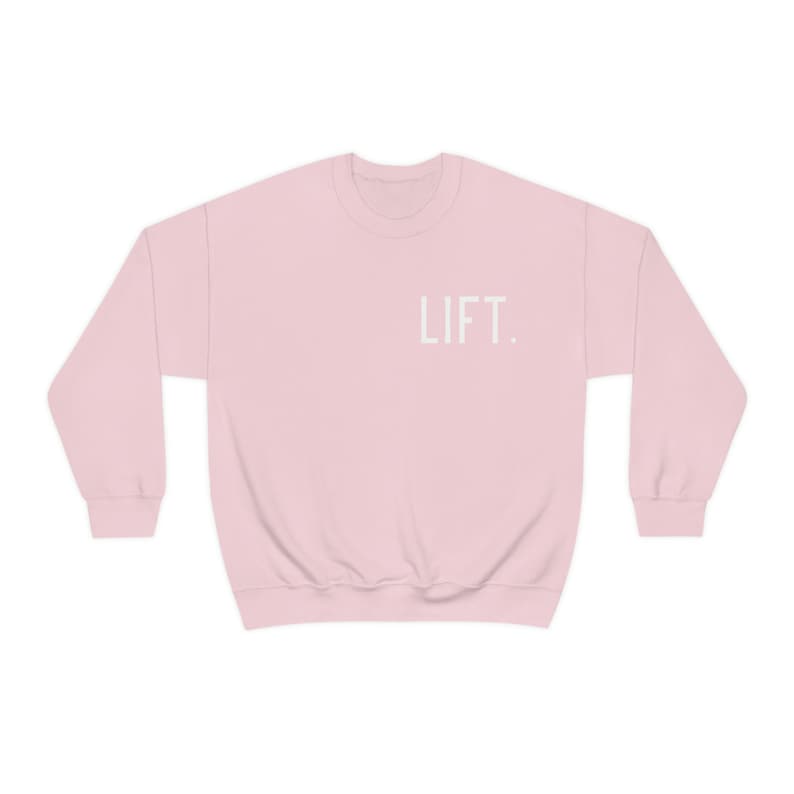 May include: A pink sweatshirt with the word "LIFT." printed in white on the front.