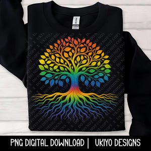 May include: Black crewneck sweatshirt featuring a vibrant, rainbow-colored tree design. The tree's roots and branches are intricately detailed, with leaves in shades of green, yellow, orange, and red. The text "PNG DIGITAL DOWNLOAD | UKIYO DESIGNS" is at the bottom.