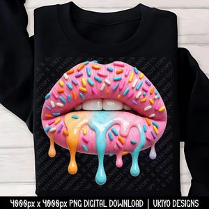 以下が含まれることがあります： 黒いスウェットシャツ。ピンク色の唇がドーナツのようにデザインされ、カラフルなスプリンクルで覆われ、オレンジ、青、ピンクのアイシングが滴り落ちています。「UKIYO DESIGNS」の文字が見えます。