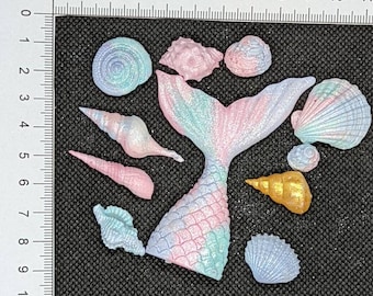 1 edible mermaid tail and 10 sea shells. Pastel shades of pink purple and teal.