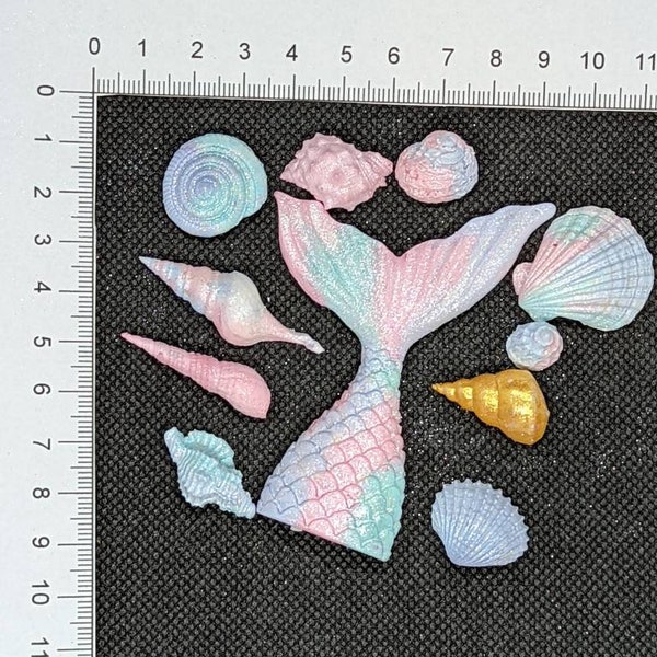 1 edible mermaid tail and 10 sea shells. Pastel shades of pink purple and teal.