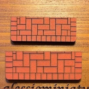 May include: Two red brick-patterned wooden tiles, each measuring approximately 4 inches by 8 inches. The tiles are designed to look like a brick walkway.