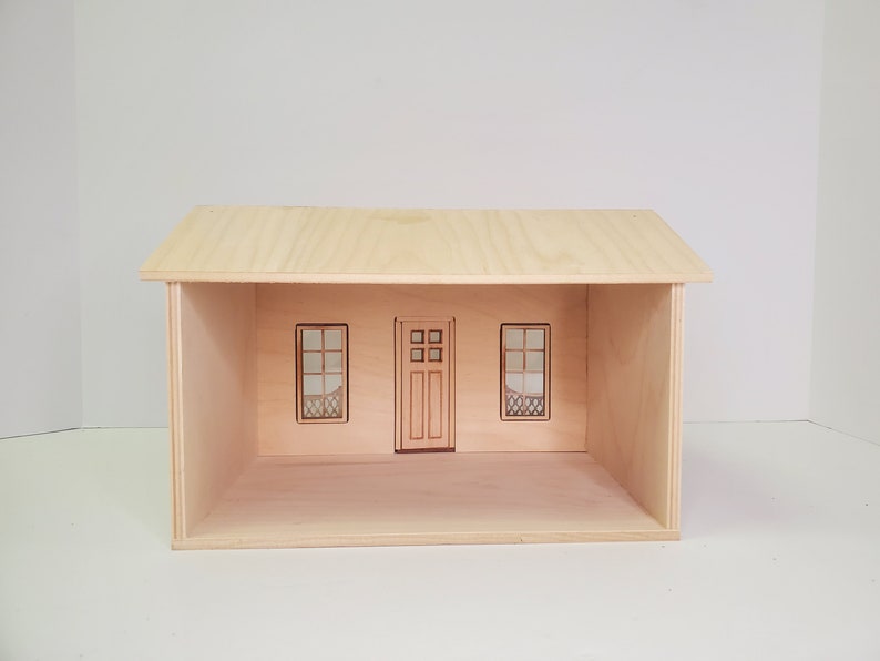Peut inclure: Une maison de poup&eacute;e en bois avec un design simple, comprenant une porte d'entr&eacute;e et deux fen&ecirc;tres. La maison de poup&eacute;e est non finie et pr&ecirc;te &agrave; &ecirc;tre peinte ou d&eacute;cor&eacute;e.