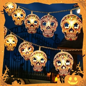 May include: A string of decorative lights featuring multiple skull-shaped bulbs. Each skull is white with intricate, colorful floral and geometric patterns in red, green, and yellow. The lights emit a warm glow from within each skull design.
