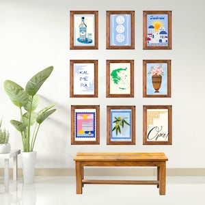 May include: Nine framed prints with various Greek-themed designs, including a bottle of Ouzo, a map of Greece, a vase of flowers, and the words "Kalime ra" and "Opa!" The prints are arranged in a grid on a white wall above a wooden bench.