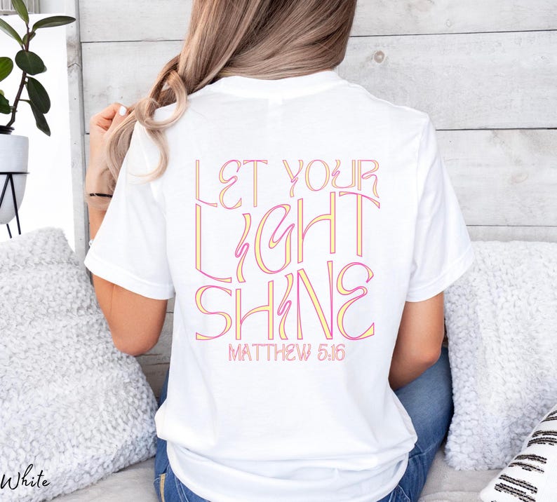 May include: White t-shirt with the text "Let your light shine" in pink and yellow lettering. The text "Matthew 5:16" is printed below the main text.