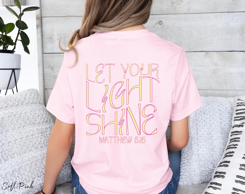 May include: A pink t-shirt with the text "Let Your Light Shine" and "Matthew 5:16" in a colorful, outlined font.