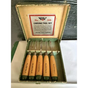 May include: A vintage Millers Falls Tools No. 106 carving tool set in a green box. The set includes five metal carving tools with light wood handles, each stamped with the brand name. The box lid features a label with the text Carving Tool Set.