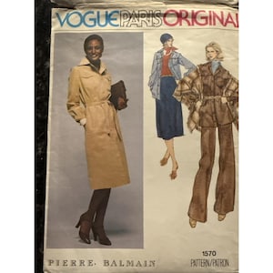 May include: Vogue Paris Original sewing pattern featuring a woman in a tan trench coat and illustrations of other outfits. The pattern is labeled "1570" and includes the designer's name, Pierre Balmain.