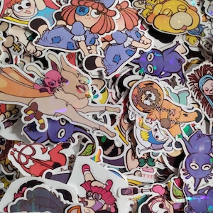 Puede incluir: Una colección de pegatinas coloridas con personajes de dibujos animados, animales y diseños abstractos. Las pegatinas están hechas de vinilo y tienen un acabado brillante.