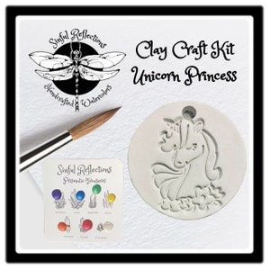 May include: A clay craft kit featuring a unicorn princess design. The kit includes a white ceramic mold, a paintbrush, and a small card with a variety of gemstone colors.